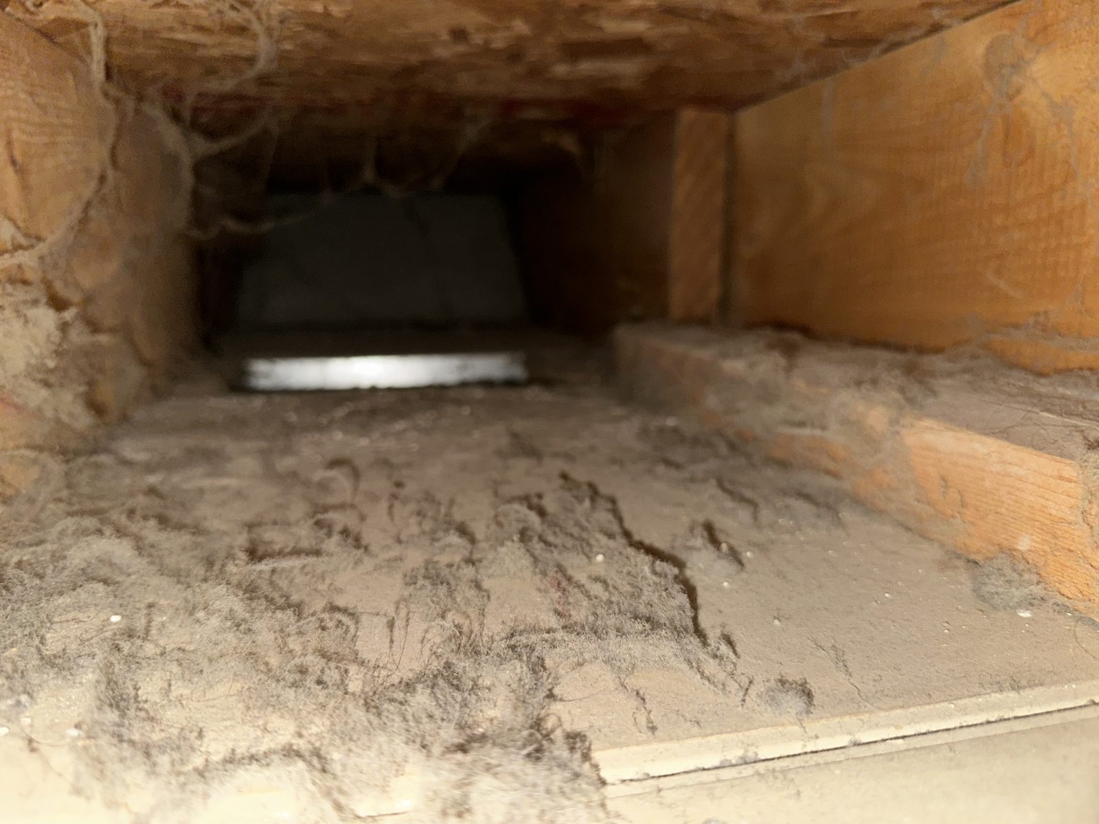 Air duct coated with heavy dust and debris before cleaning