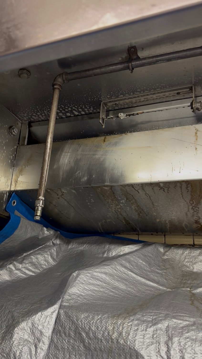 Commercial kitchen exhaust hood with grease buildup before cleaning